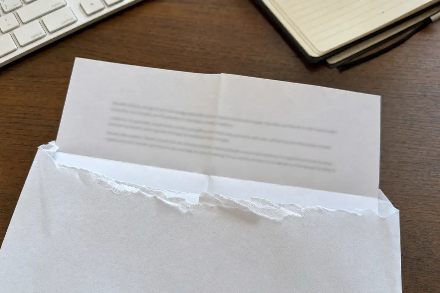 Lettre pliée à demi sortie de son enveloppe ouverte